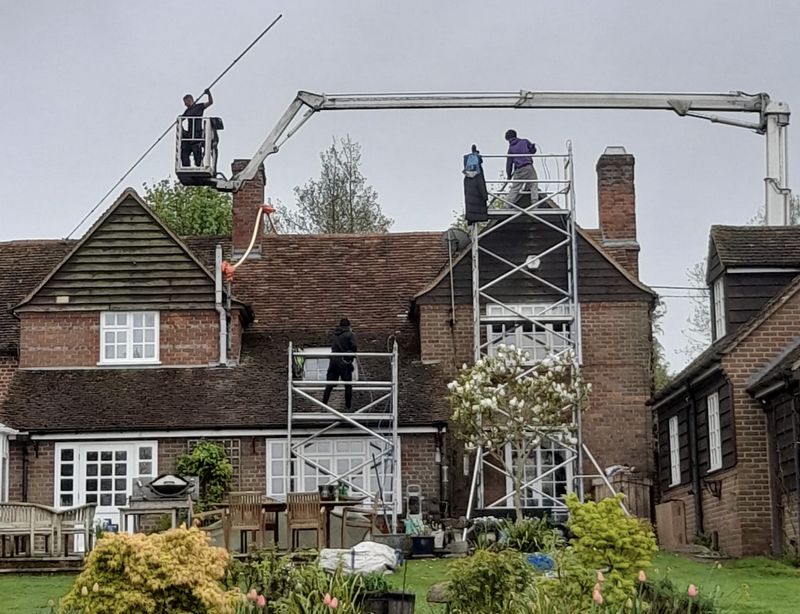 The Moss Cleaners using cherry picker and scaffolding to clean roof safely and professionally in Hilperton, Wiltshire